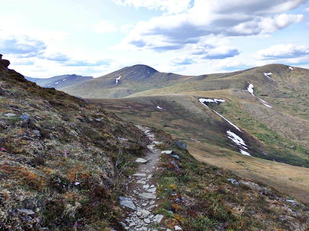 This photo was taken shortly before the 2 mile marker, looking westward along the trail. The tall hill in the distance (center) is Porcupine Dome.